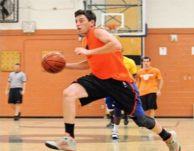 Basketball player dribbling to the basket.