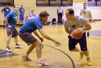 Male player in basketball league playing tight defense.