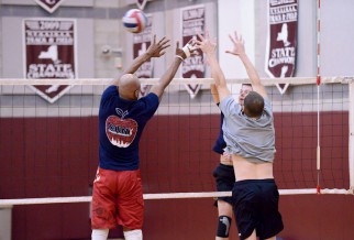 Nyc men's volleyball game with players blocking the spike.