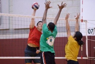 Men block a shot in NYC volleybal league