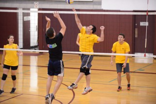 Player in yellow spikes in volleyball league game